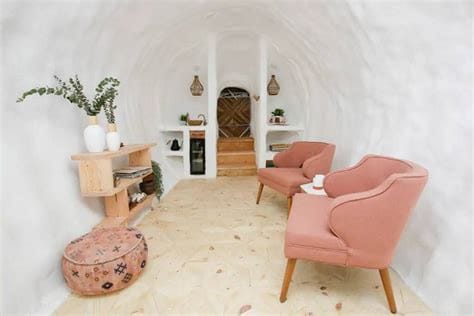Interior of the potato Airbnb with pink chairs and queen bed