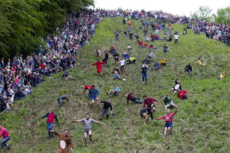 Competitors tumbling down Cooper’s Hill chasing a wheel of cheese.