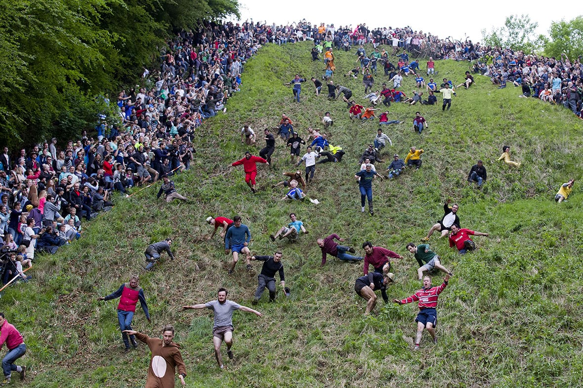 Competitors tumbling down Cooper’s Hill chasing a wheel of cheese.