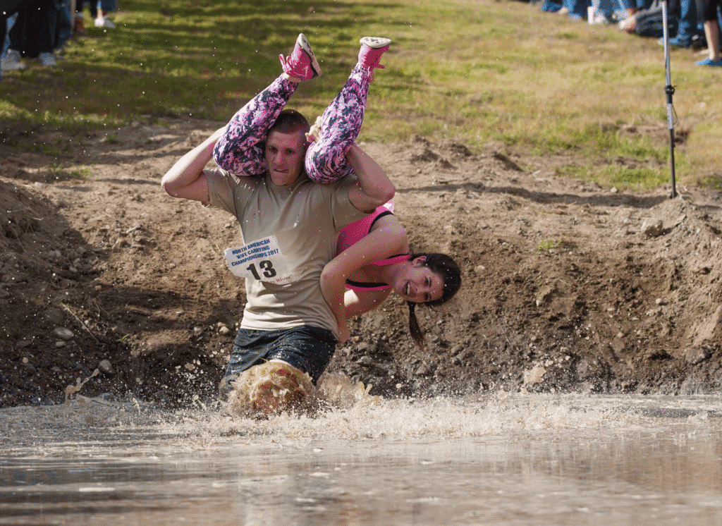 Wife carrying sport. A man carrying his wife in a relay sport
