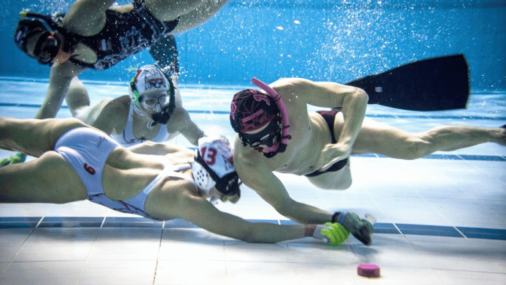 Divers competing in an underwater hockey match, a rare and adventurous unusual sport played at the bottom of a swimming pool.