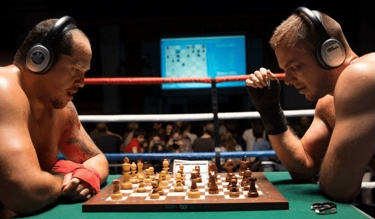 Two athletes are competing in chess boxing, an unusual sport combining intense boxing rounds with strategic chess gameplay.
