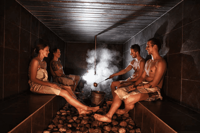 People enjoying a Finnish sauna, showcasing the tradition that contributes to Finland’s happiness secrets