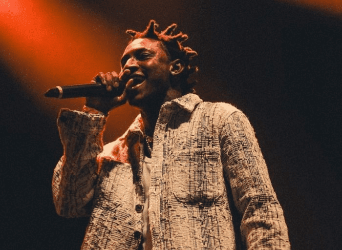 Shallipopi engaging with a lively crowd at an outdoor event in Lagos, showcasing his charisma and street appeal in the Afrobeat scene. Afrobeat artists 2025.